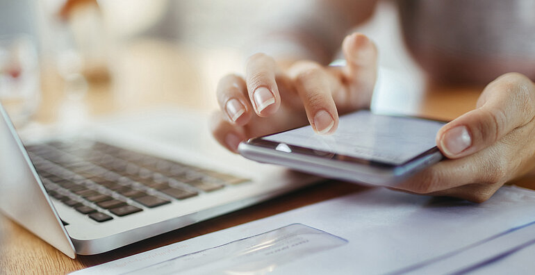 Journalist arbeitet an Laptop und Smartphone